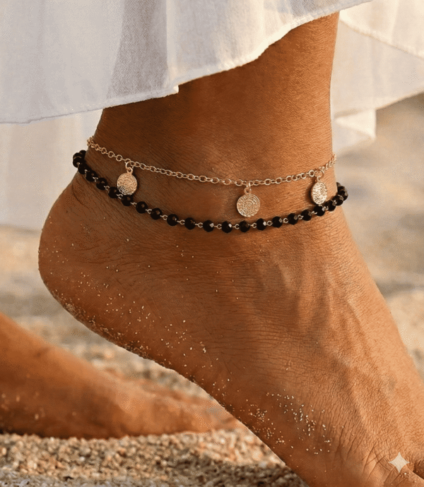 خلخال ذهبي مزين بحبات سوداء وتصميم أنيق يزين الكاحل