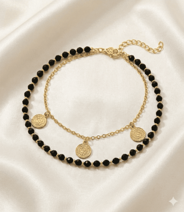 خلخال ذهبي مزين بحبات سوداء وتصميم أنيق يزين الكاحل