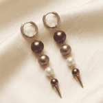 أقراط نسائية أنيقة بتصميم انسيابي تجمع بين لؤلؤتين بتفاصيل ذهبية ناعمة