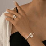 طقم مجوهرات أنيق يتكون من سوار وخاتم بتصميم راقٍ يجمع بين بريق الكريستال وجمال حبات اللؤلؤ المتناسقة. يمنح التصميم لمسة فخامة وأنوثة مميزة، مما يجعله مثالياً للمناسبات والإطلالات الراقية.