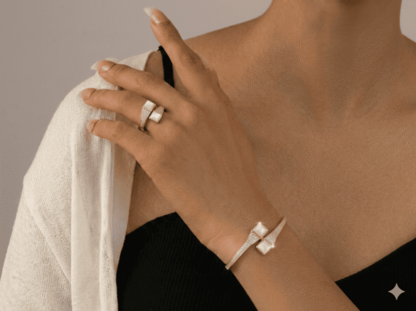 طقم مجوهرات أنيق يتكون من سوار وخاتم بتصميم راقٍ يجمع بين بريق الكريستال وجمال حبات اللؤلؤ المتناسقة. يمنح التصميم لمسة فخامة وأنوثة مميزة، مما يجعله مثالياً للمناسبات والإطلالات الراقية.