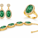طقم مجوهرات فاخر يضم أقراطًا وخاتمًا وسوارًا بحجر بيضاوي أخضر محاط بكريستالات لامعة وإطار ذهبي أنيق.