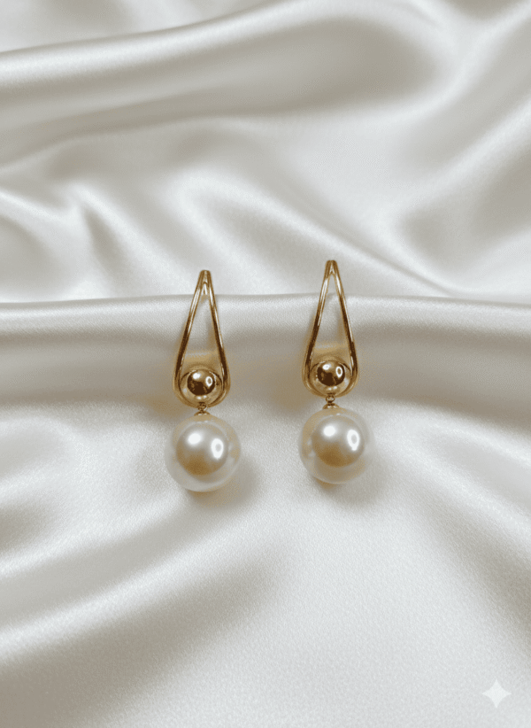 أقراط نسائية أنيقة بتصميم انسيابي تجمع بين لؤلؤتين بتفاصيل ذهبية ناعمة