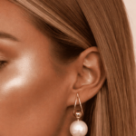 أقراط نسائية أنيقة بتصميم انسيابي تجمع بين لؤلؤتين بتفاصيل ذهبية ناعمة