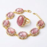 طقم مجوهرات فاخر بحجر كوارتز الفراولة الوردي يضم سوارًا وخاتمًا بتصميم أنيق ولمسات ذهبية مرصعة.