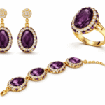 طقم مجوهرات فاخر يضم أقراطًا وخاتمًا وسوارًا بحجر بيضاوي قرمزي محاط بكريستالات لامعة وإطار ذهبي أنيق.