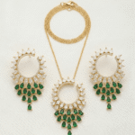 طقم مجوهرات ذهبي يتكون من عقد وأقراط مرصعة بالكريستال وحجر الزمرد الأخضر