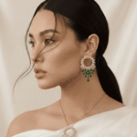 طقم مجوهرات ذهبي يتكون من عقد وأقراط مرصعة بالكريستال وحجر الزمرد الأخضر